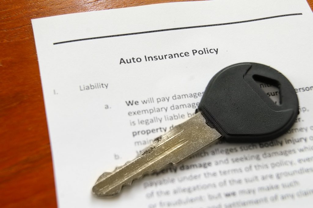 Car insurance with car key on top
