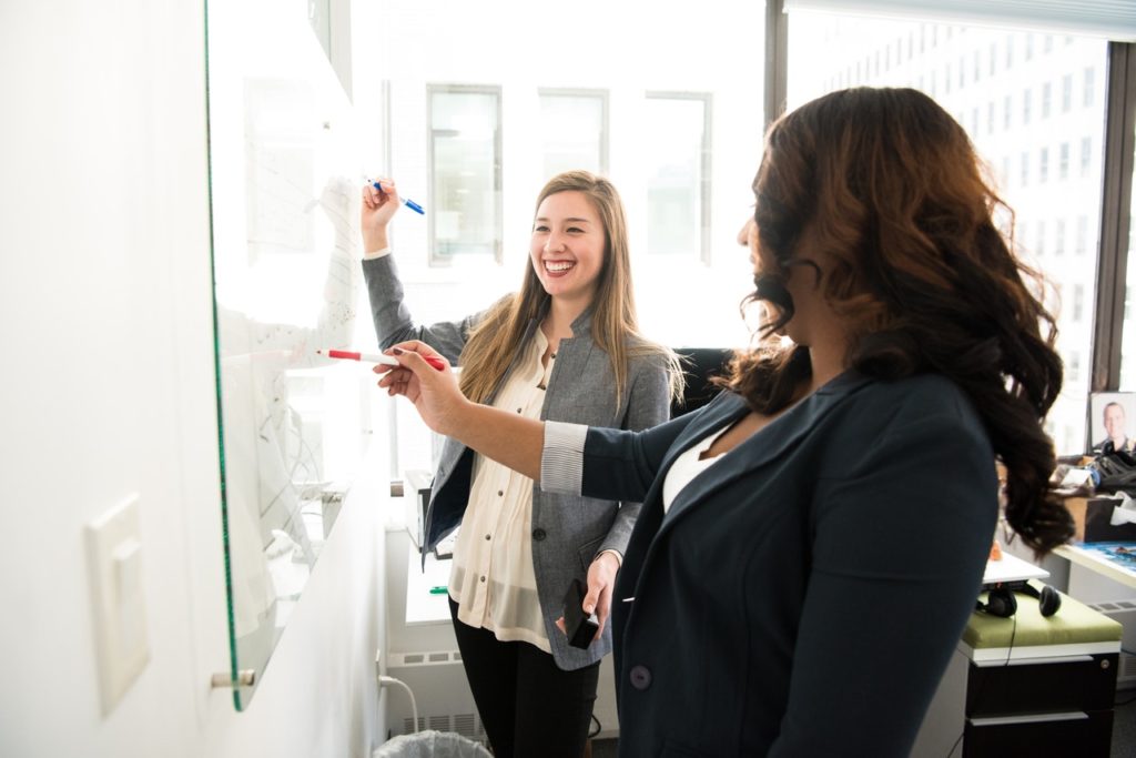 women looking at a whiteboard