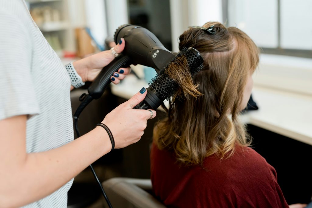 hairdresser blow-drying a client's hair