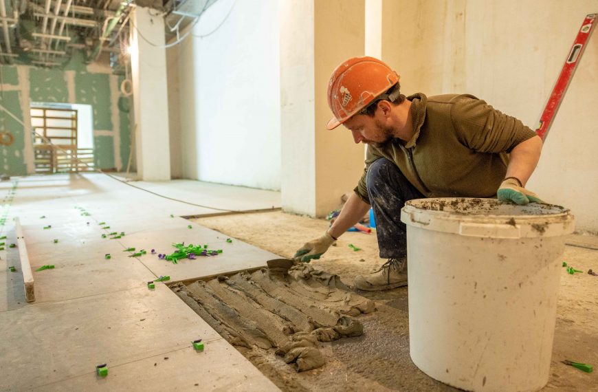 construction worker laying tiles during a retail store renovation